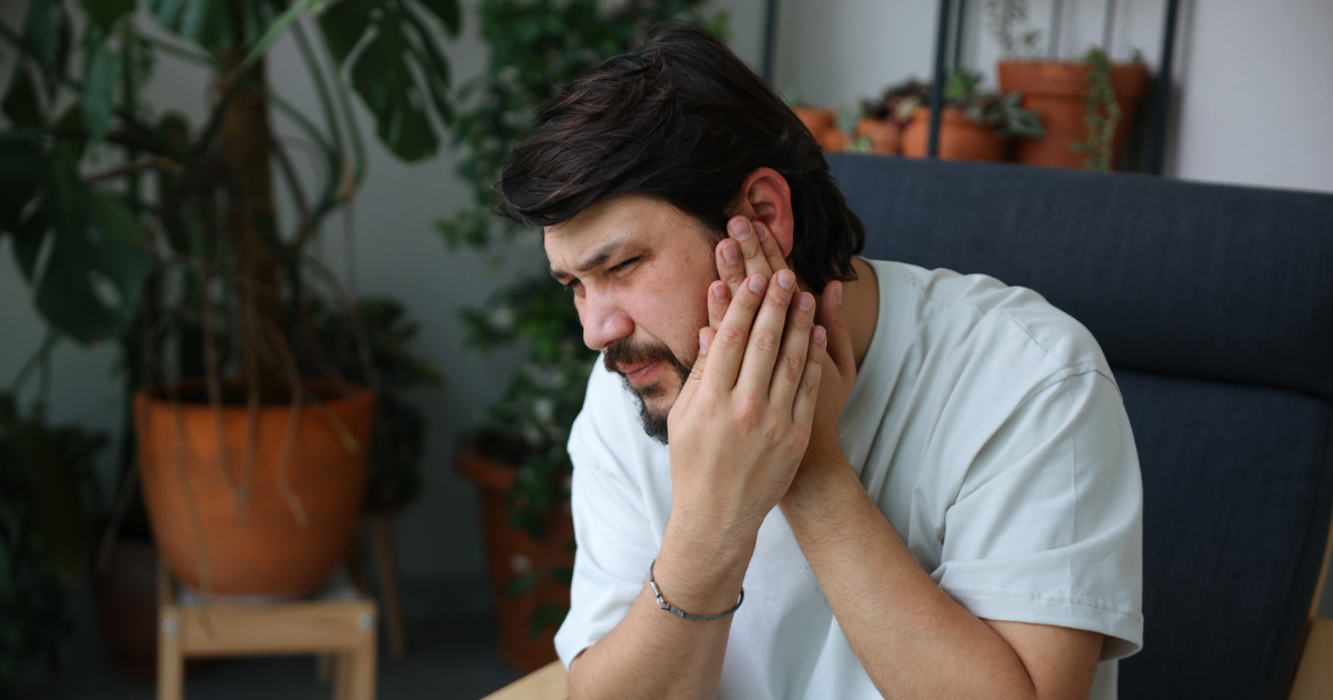 Man holding his ear