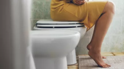 Woman sitting on top of a toilet