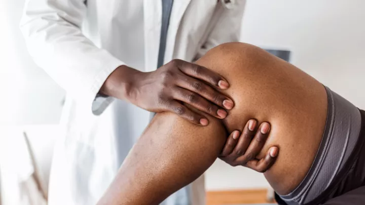 Close up of doctor examining patient's knee