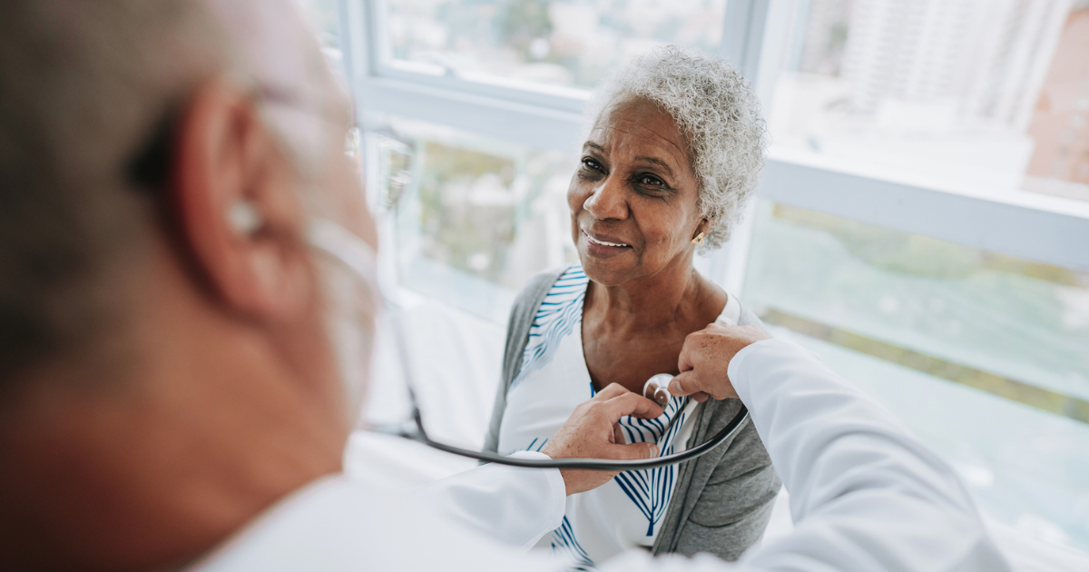 Portrait of a doctor listening to an elderly woman patient's heartbeat
