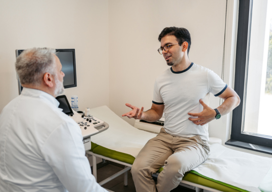 Man talking to doctor about stomach pain