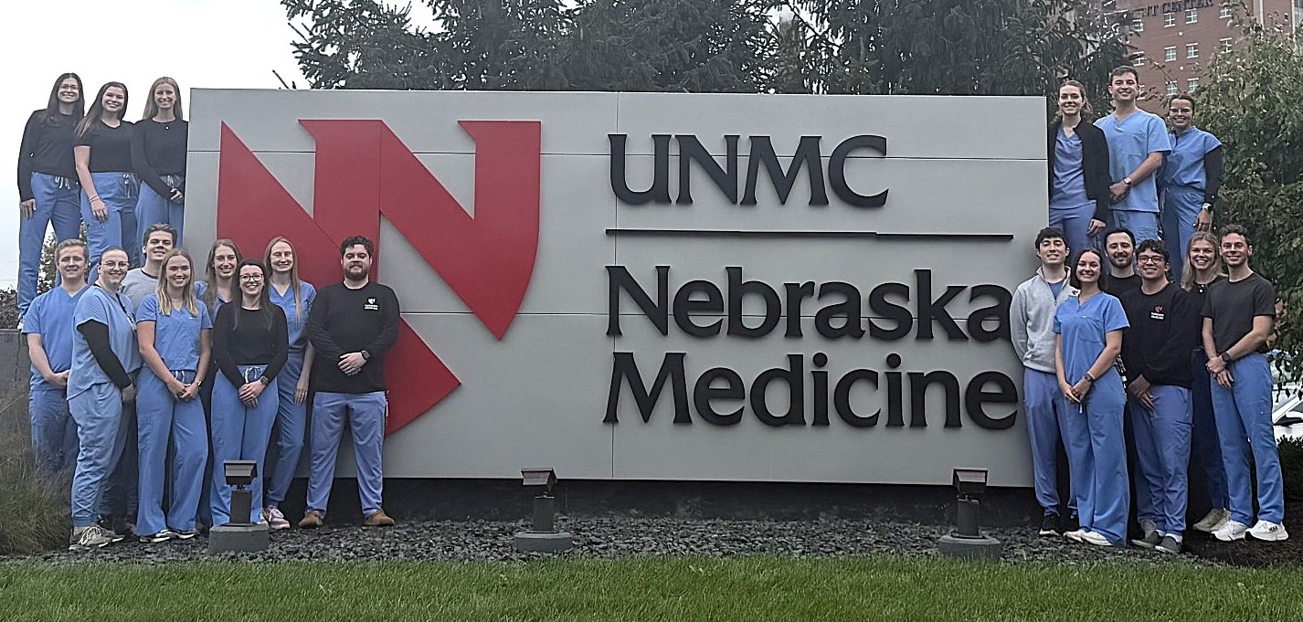 Pharmacy residents standing by UNMC | Nebraska Medicine sign