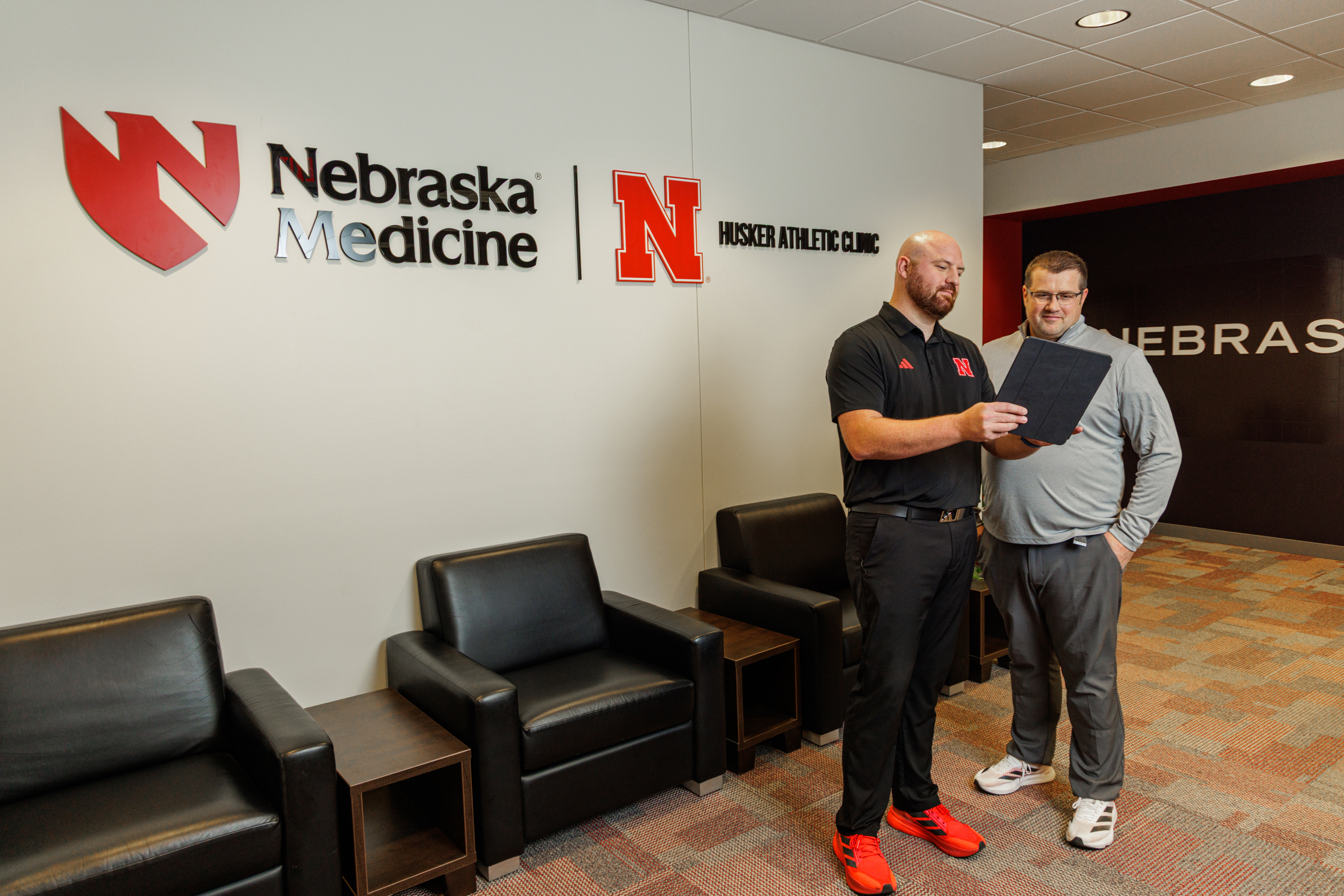 Dr. Tomesch and Dr. Mathiasen in front of the dual-branded wall