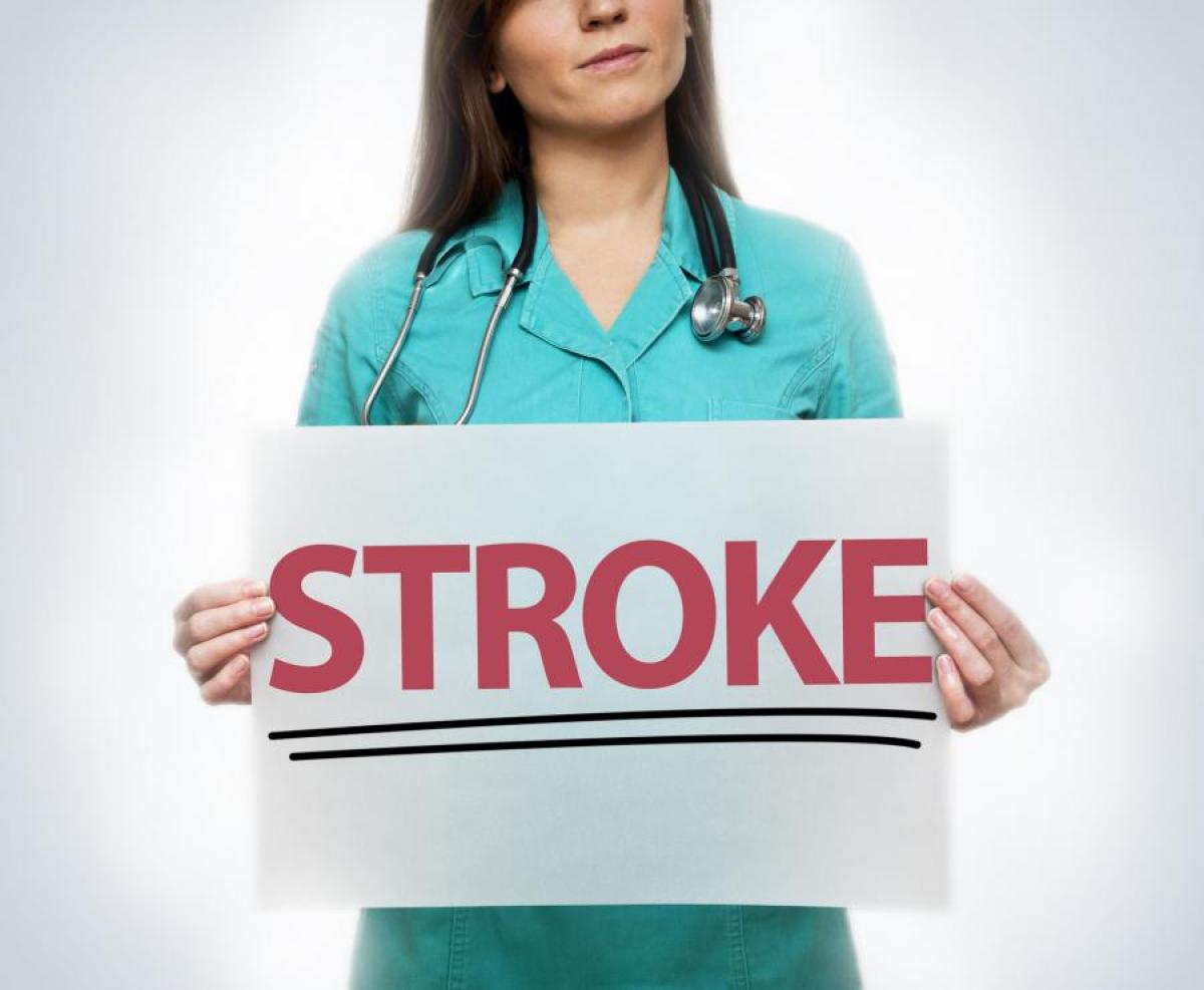 Woman holding sign that says STROKE