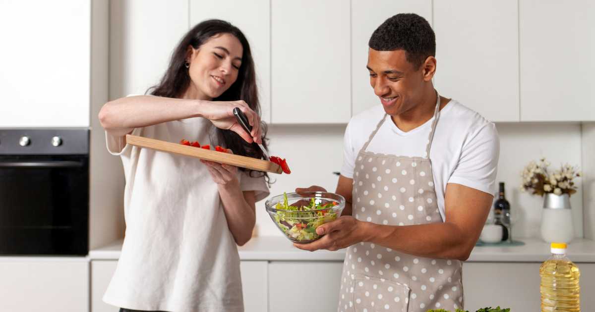 Man and woman in kitchen making a salad