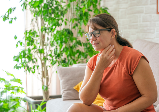 Woman holding her throat
