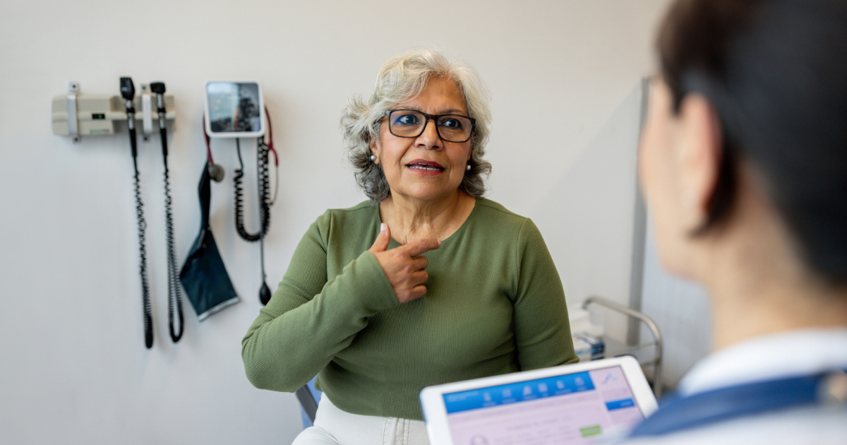 Older woman talking to doctor about throat pain