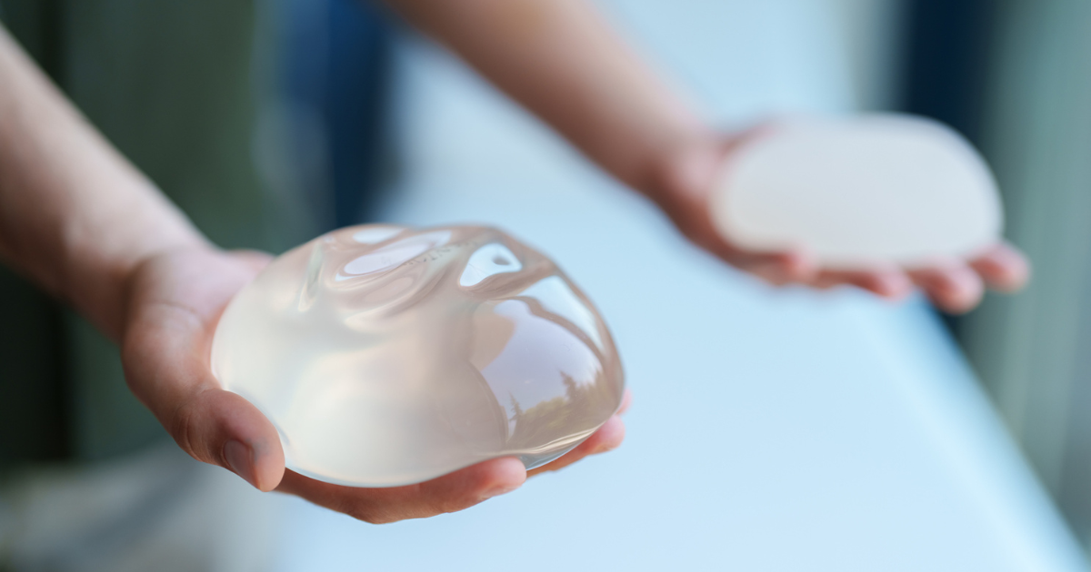 Hands holding saline breast implants