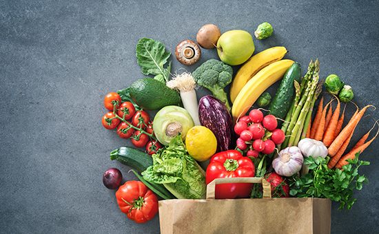 Tipped over bag of fruits and vegetables. 