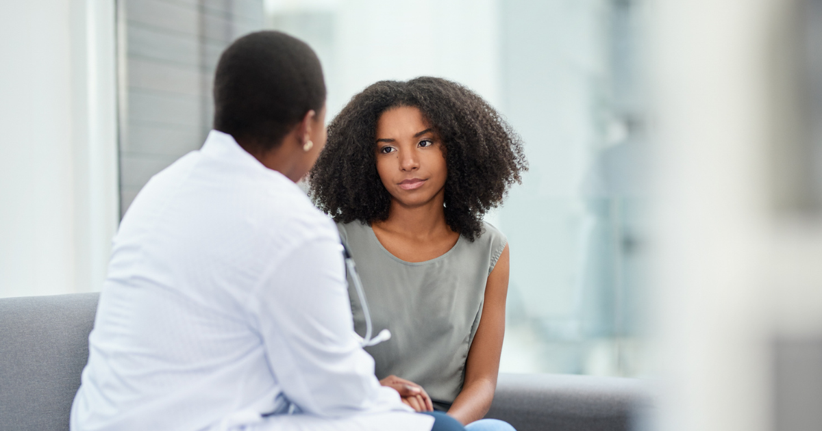 Young woman talking to doctor