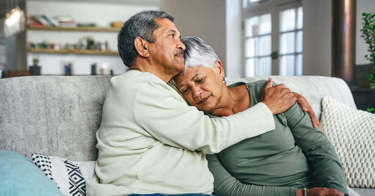 Man and woman sitting and hugging on couch