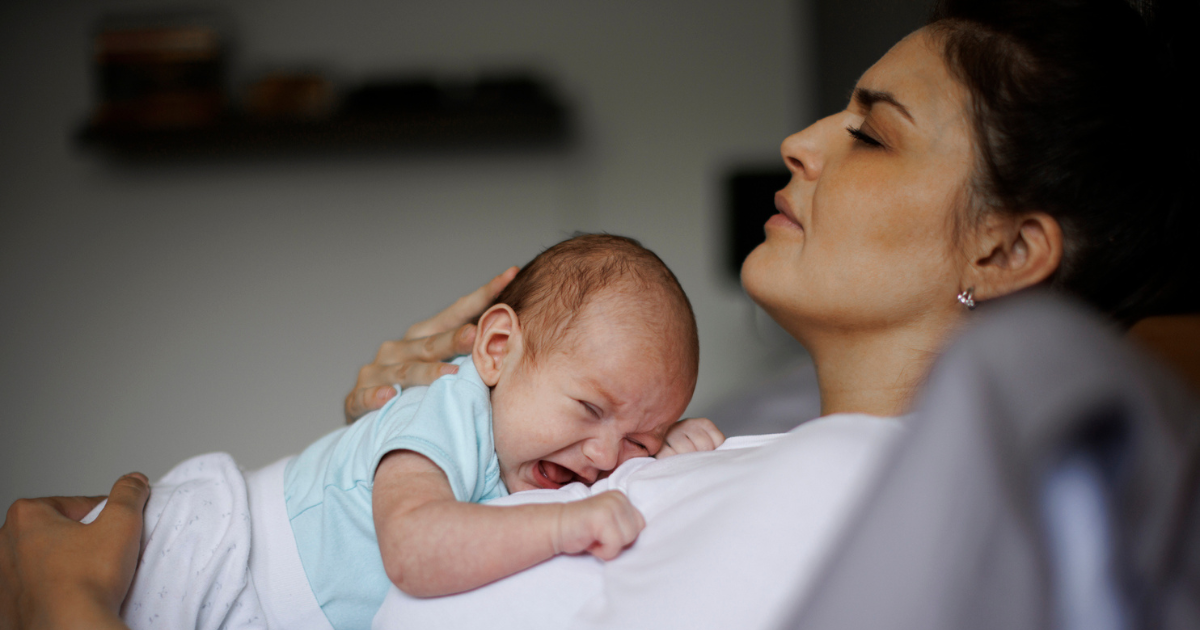 Tired mother holding her baby