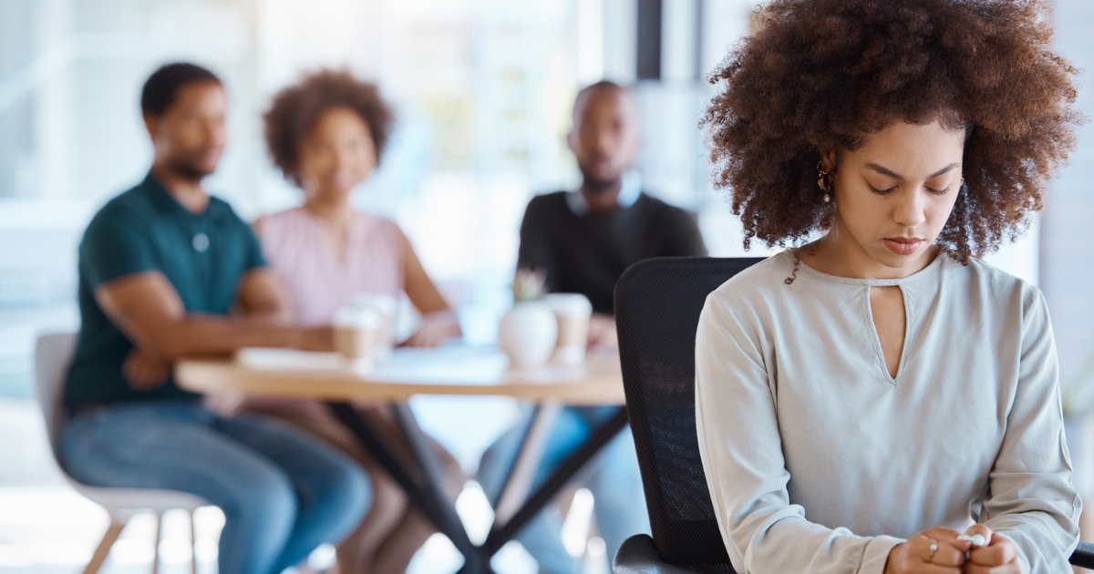 Woman sitting away from group