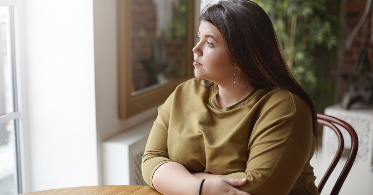 Woman sitting at a table looking out the window