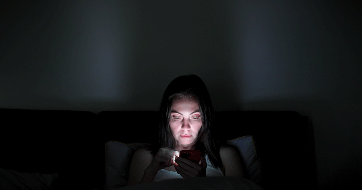 Woman in the dark looking at a screen
