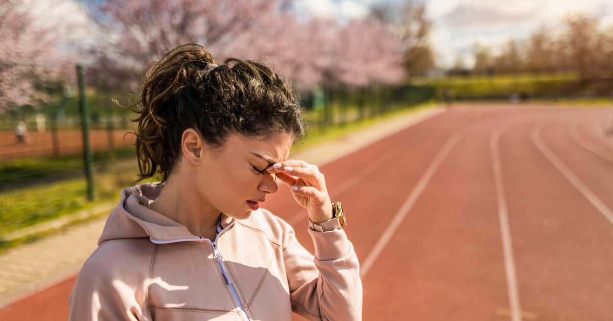 Picture of a woman on a track with a headache