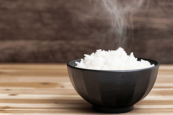 A small black bowl full of white rice.