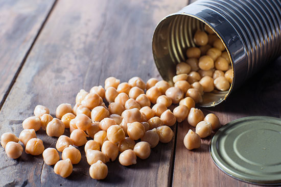 Canned chickpeas spilling out onto a table.