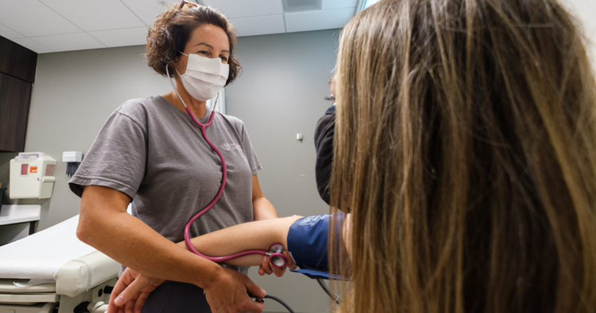 Nurse taking woman's blood pressure