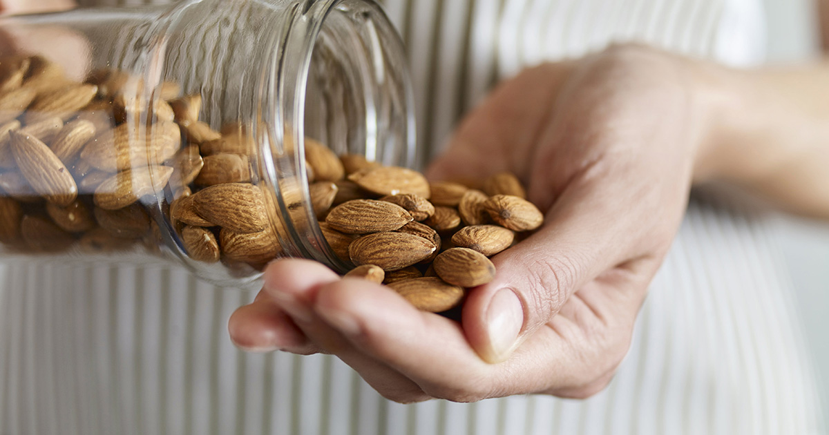Close up of woman pouring almonds into her hand