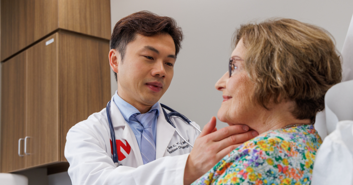 Dr. Lo feeling patient's neck