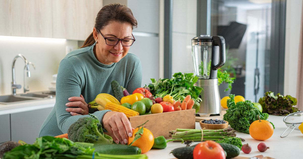 Older woman with a counter full of fruits and vegetables