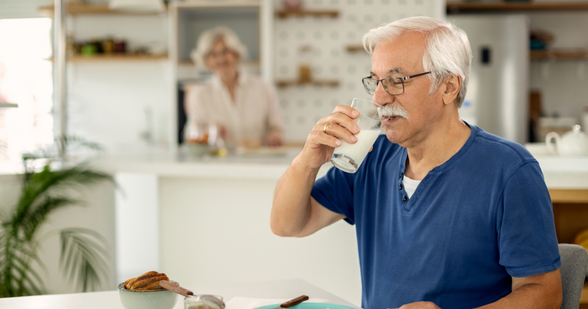 Man drinking milk at breakfast table