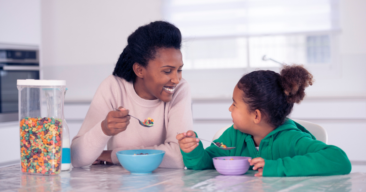 Woman and her daughter eating colorful cereal