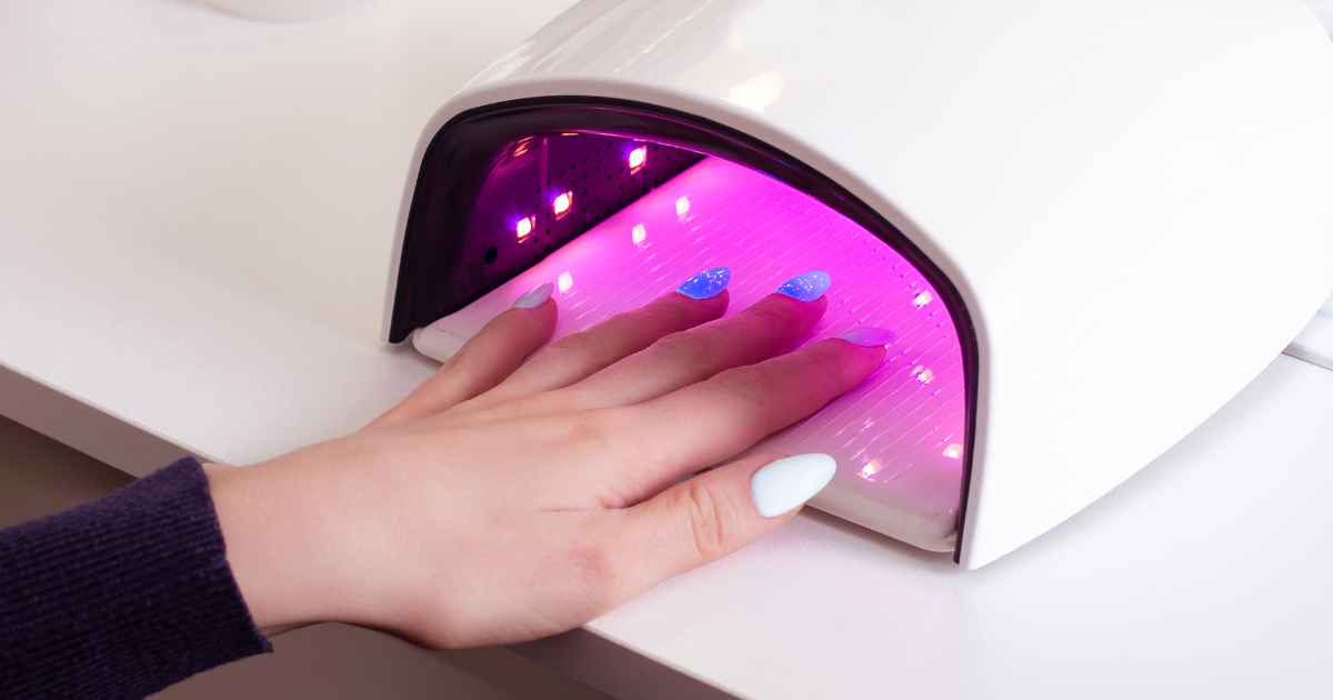Woman's hand in UV nail dryer