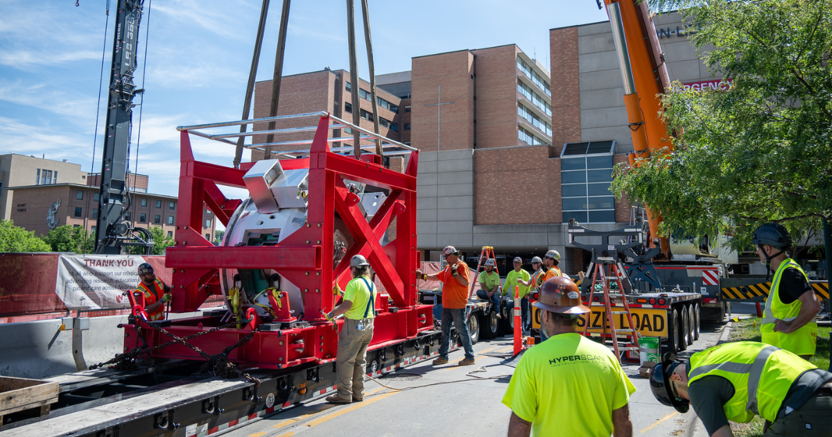 Proton therapy machine being lowered via crane.