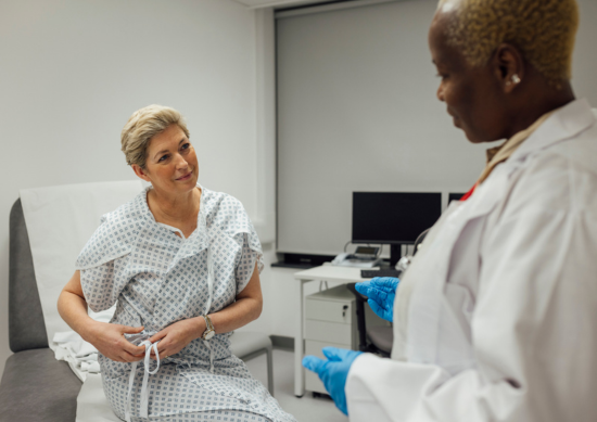 Woman sitting on exam table talking to her doctor