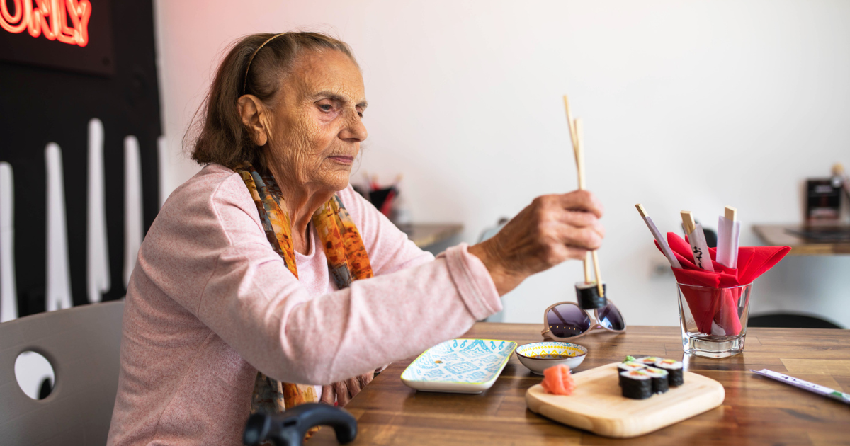 Older woman eating sushi