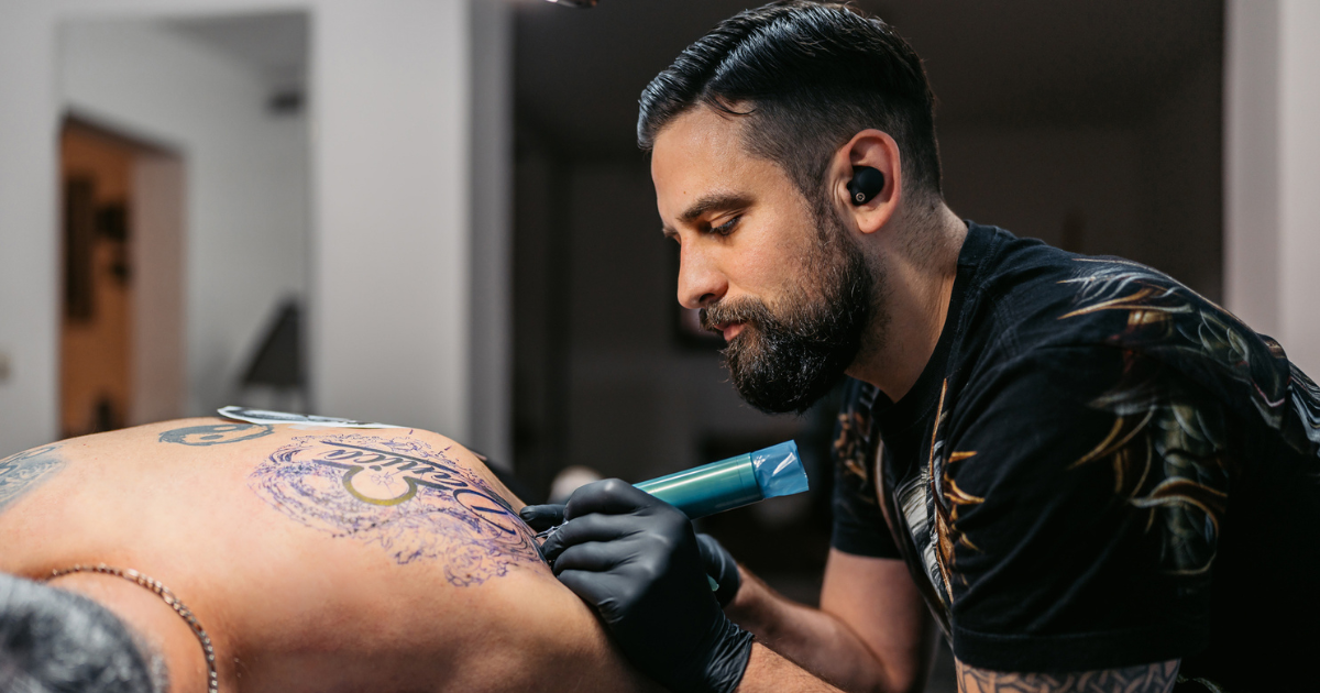 Man tattooing a man's back