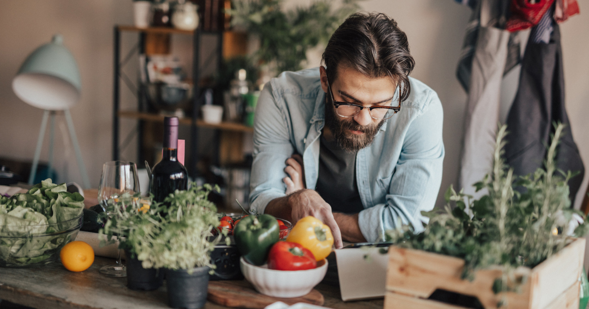 Man in kitchen looking at tablet