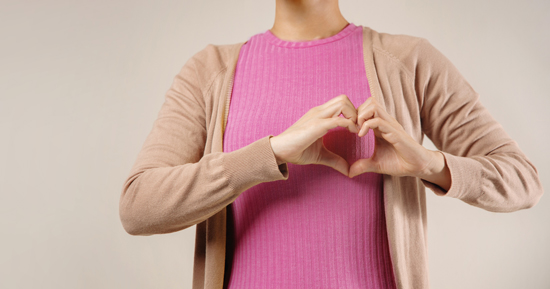 picture of a woman making a heart with her hands