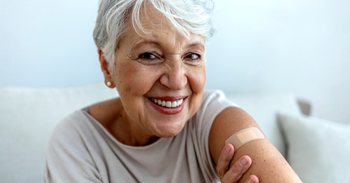 Older woman smiling with bandage on her arm