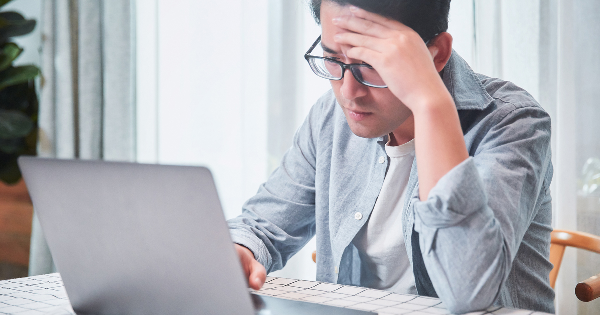 Man at computer. Looks frustrated.