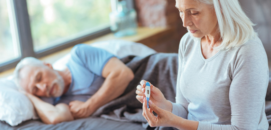 picture of a woman taking her sick partner's temperature