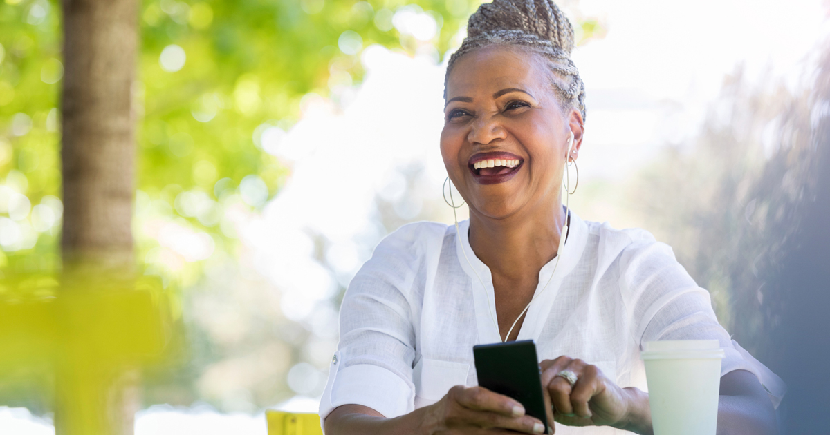 Older woman smiling holding her phone