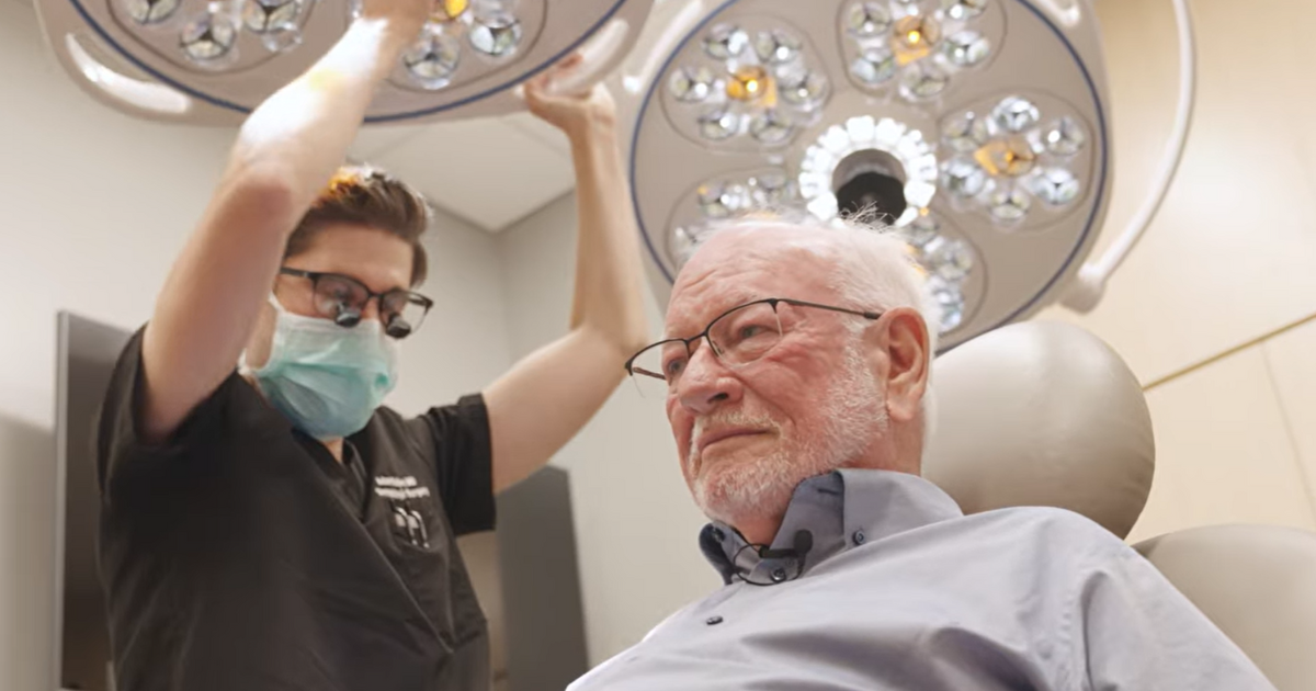 Dr. Sutton looking at Douglas Smith's scalp