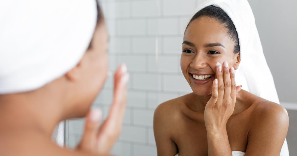 Woman applying cream to her face