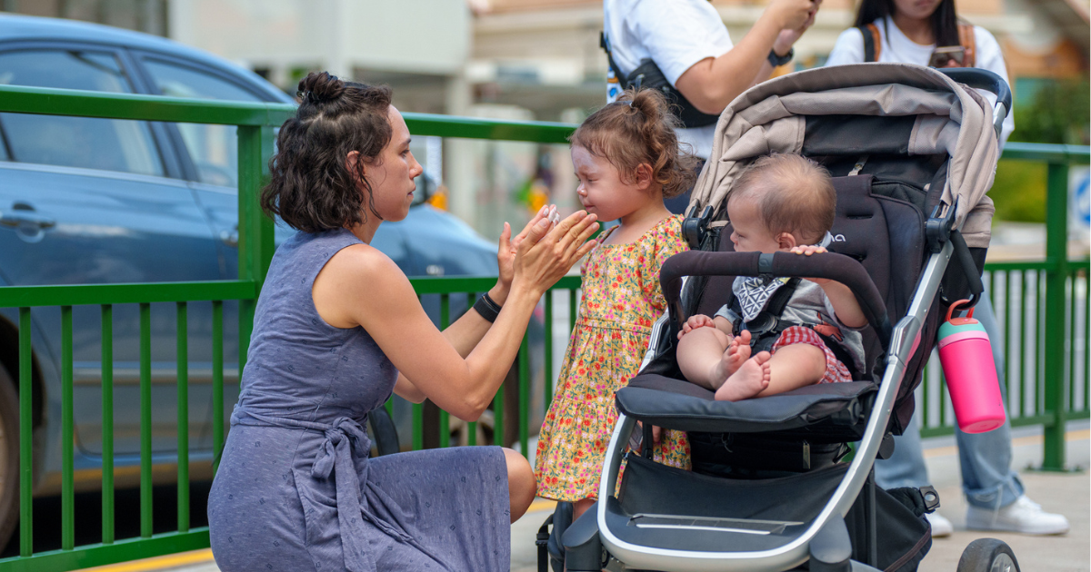 Mom putting sunscreen on her two children