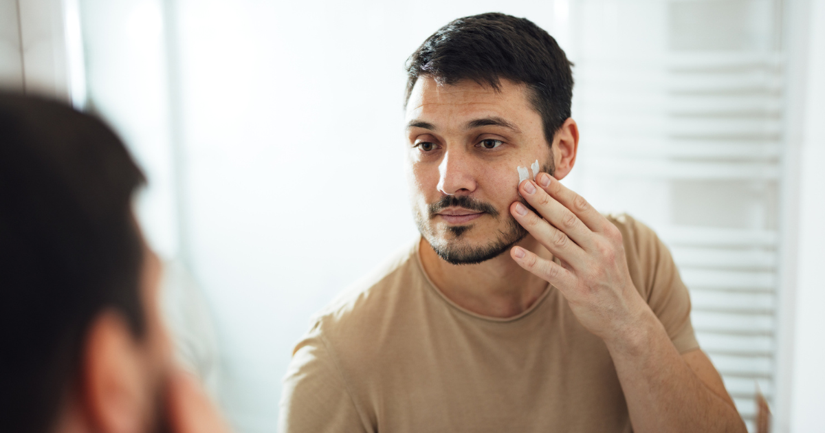 Man putting moisturizer on his face