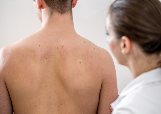 Doctor looking at man's back