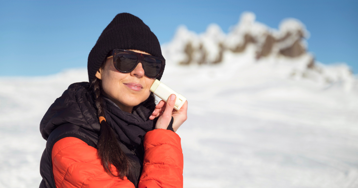 Woman applying sunscreen to her face