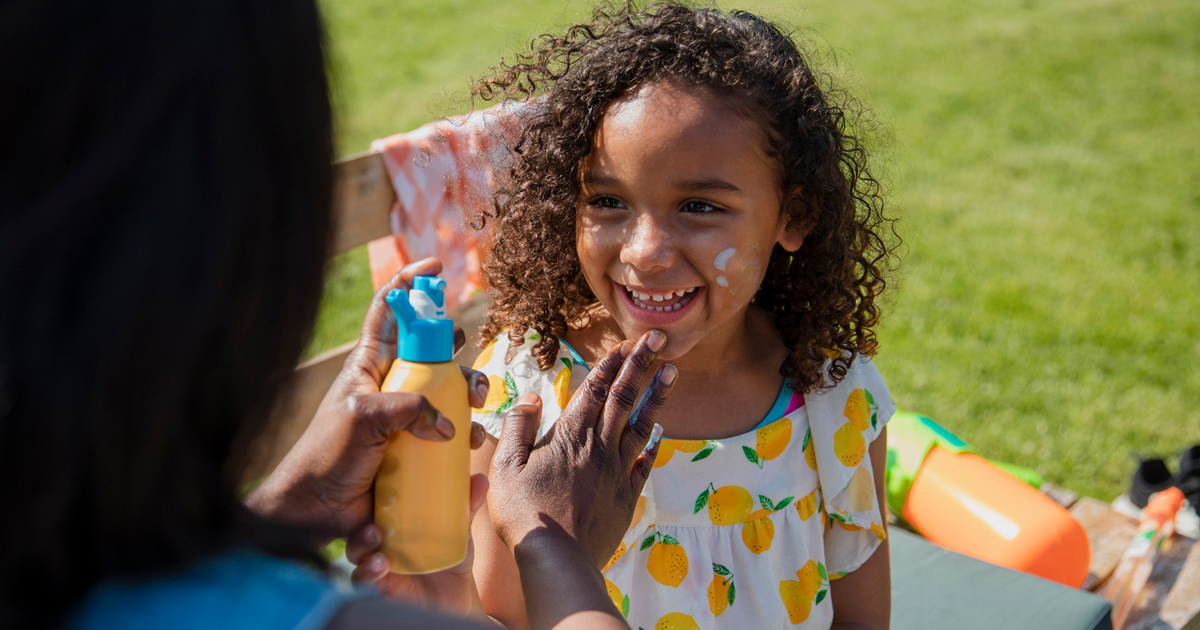 A mother putting sunscreen on a young girl