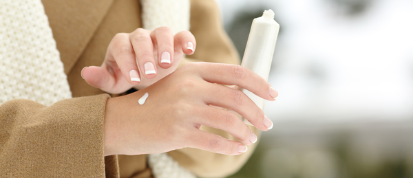Woman applying hand lotion in the winter