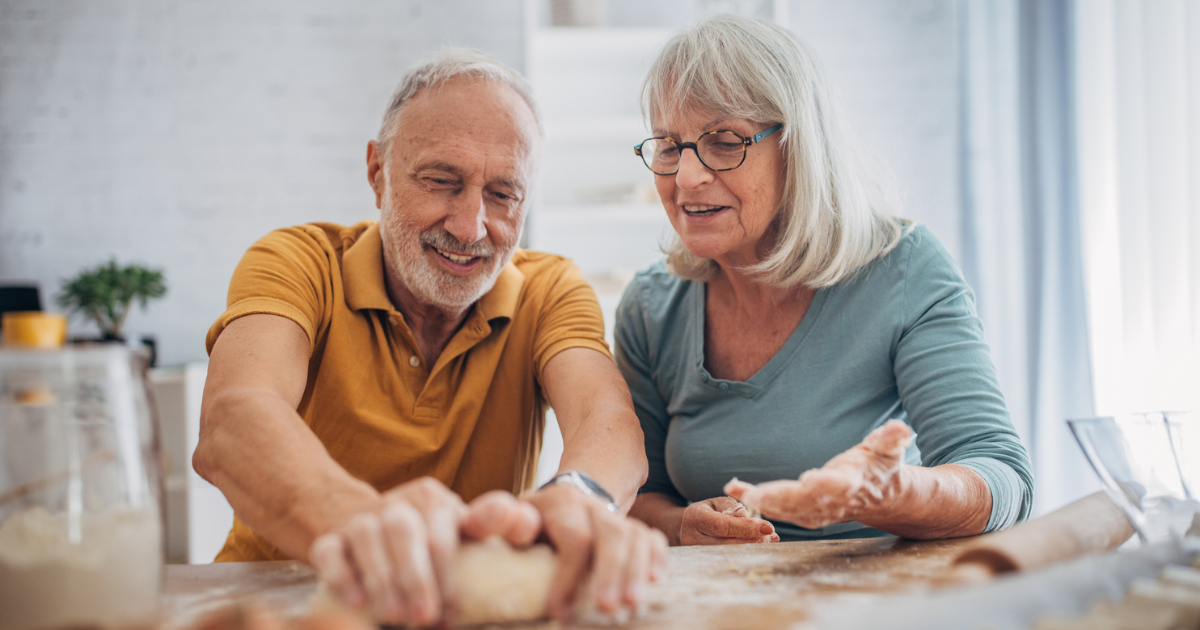 Older man and woman kneading dough