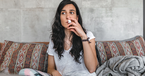 picture of a woman using nasal spray