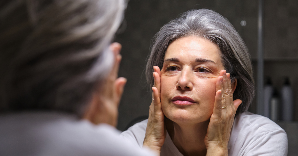 Woman looking at her face in the mirror